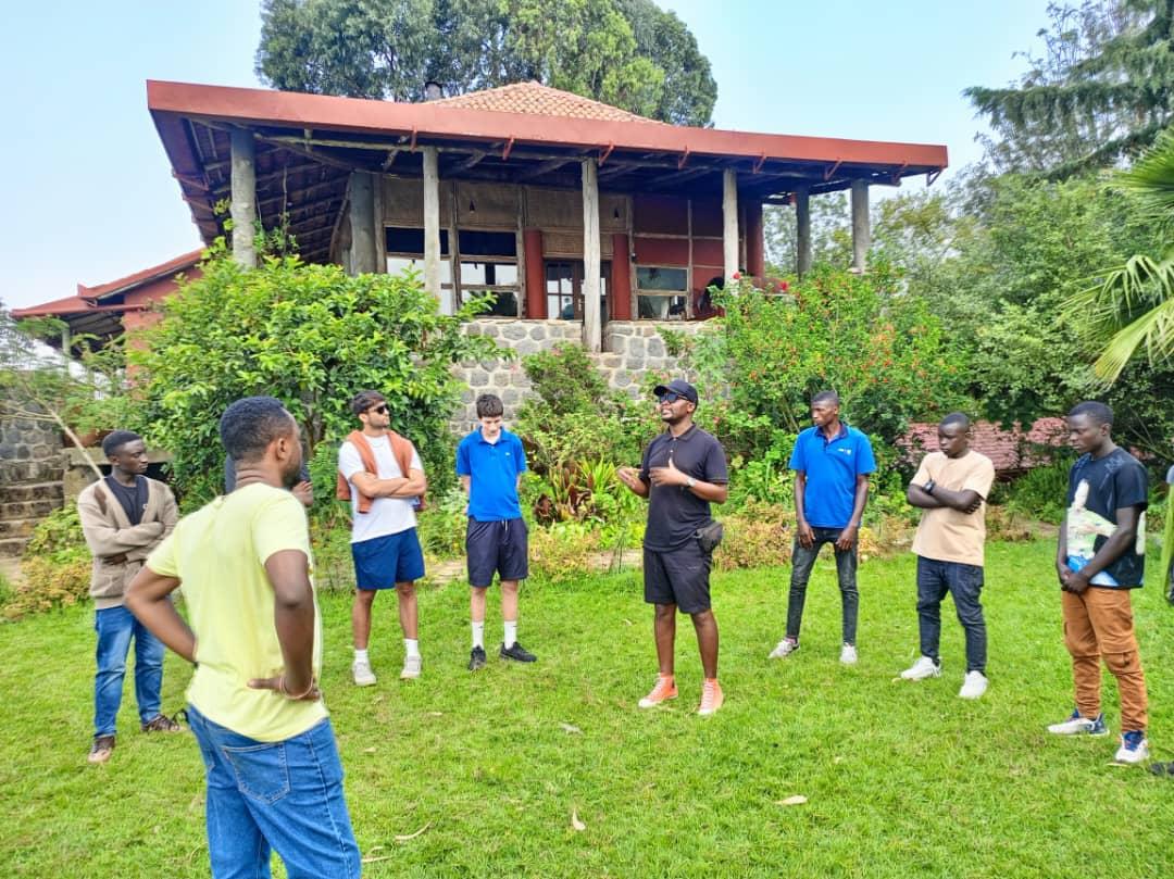 Students and peer educators playing lawn games together in a wide circle.